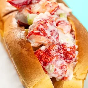 Close-up of a buttery New England lobster roll filled with wild-caught Maine lobster meat and creamy dressing
